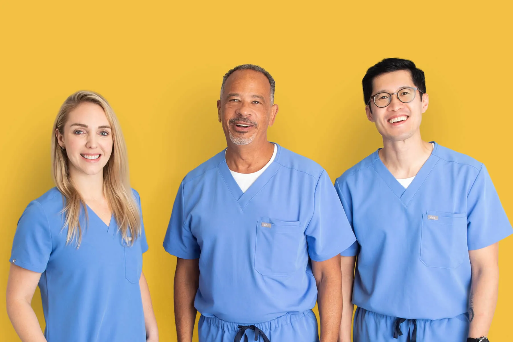 Three vein care physicians in blue scrubs smiling